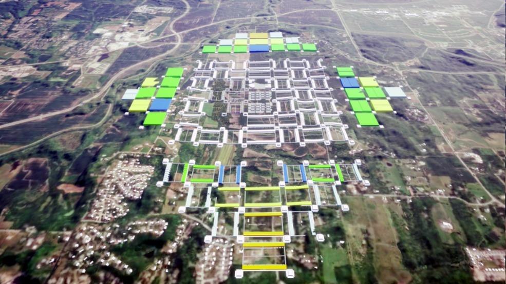 Aerial photograph overlaid with a diamond-shaped diagram of a complete NewVistas community, showing the central buildings and surrounding hinterland